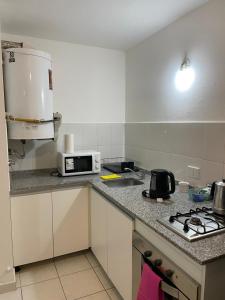 cocina pequeña con fogones y microondas en Departamento Montevideo en zona NUEVA CORDOBA en Córdoba