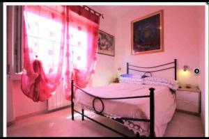 a bedroom with a bed with pink curtains and a window at Subito disponibile! in Cinisello Balsamo