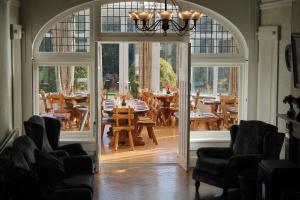 uma sala de jantar com mesas e cadeiras e uma porta aberta em Riversdale Farm B&B em Ballinamore