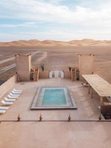 einen Pool mitten in der Wüste in der Unterkunft Dar Morocco in Merzouga