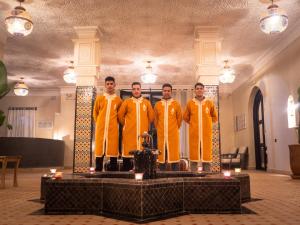 a group of men in yellow robes standing on a table at Dar Morocco in Merzouga