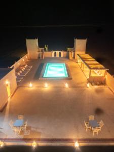 an overhead view of a swimming pool at night at Dar Morocco in Merzouga
