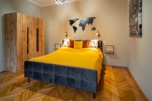 Un dormitorio con una gran cama amarilla con un mapa en la pared en Belvárosi apartman 'Bronze' en Miskolc