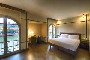 a bedroom with a bed and a large window at Hotel Balestri - WTB Hotels in Florence