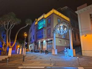 a building with christmas lights on a street at night at La Casita del Arco Panorámico in San Pedro