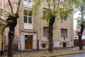 un edificio con una puerta marrón y dos árboles en Belvárosi apartman 'Bronze', en Miskolc