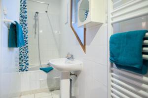a white bathroom with a sink and a shower at Chalet d'hôtes Auris in Auris