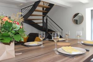 einen Esstisch mit Weingläsern und eine Treppe in der Unterkunft Gîte avec piscine intérieure in Moyrazès