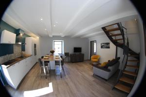 eine Küche und ein Wohnzimmer mit einer Wendeltreppe in einem Zimmer in der Unterkunft Gîte avec piscine intérieure in Moyrazès