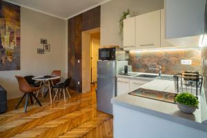 uma cozinha com um frigorífico e uma mesa com cadeiras em Belvárosi apartman 'Bronze' em Miskolc