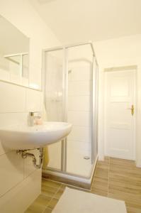 Un baño blanco con lavabo y ducha. en Apartement in Stadtvilla, en Berlín 9 fotos más