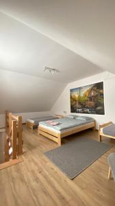 a bedroom with a bed and a painting on the wall at Apartamenty Młynne in Muszyna