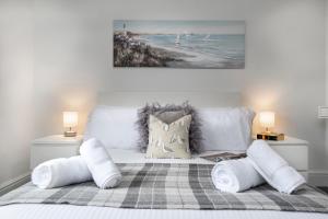 a bedroom with a bed with pillows and a beach at Pen-y-Coed ⥈ Modern ⥈ Hot Tub ⥈ Beautiful Views in Abergele