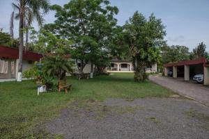 a yard in front of a house with trees at Tony Hotel in Torres