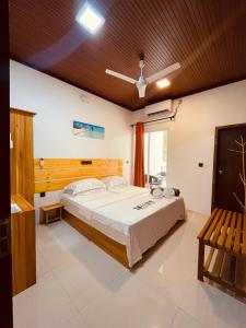 a bedroom with a large bed and a window at Huvan Inn in Fulidhoo