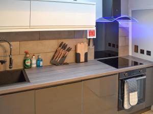 a kitchen with a counter with knives and a sink at Deleur House in Great Malvern