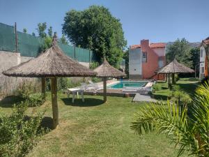 a backyard with umbrellas and a swimming pool at Cabañas El Doral in Potrero de los Funes