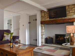 a living room with a couch and a fireplace at No 2, The Stables in Southam