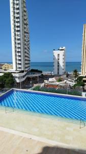 ein großer Pool vor einigen Gebäuden in der Unterkunft Cartagena 3 habitaciones 9 personas cerca a la playa Wifi y Parqueadero in Cartagena de Indias