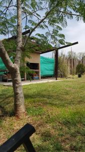 ein Park mit einem Baum und ein Gebäude mit einer grünen Plane in der Unterkunft Casa Alquiler Vacacional Maitea Ladrido del Viento in Belén de Escobar