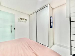 1 dormitorio con cama rosa y puerta corredera en cruzeiro novo QD 203, en Brasilia