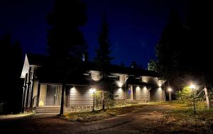 a house with lights on the side of it at night at Le-Villa Black in Levi