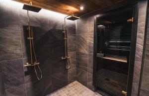 Un baño con ducha con puerta de cristal. en Le-Villa Black, en Levi 9 fotos más