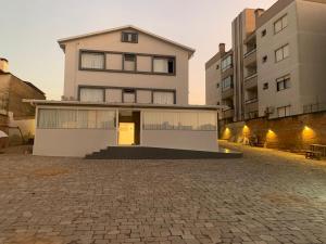 ein Haus mit einer steinernen Einfahrt vor zwei Gebäuden in der Unterkunft Hotel Villa Inácia in Vacaria