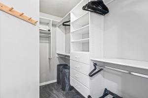 a walk in closet with white cabinets and drawers at Quiet Comfortable Cliffside Estate near USU in Logan