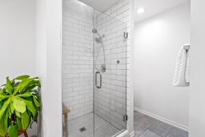 a bathroom with a shower with white tiles at Quiet Comfortable Cliffside Estate near USU in Logan