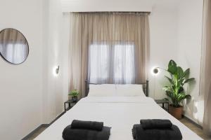 een slaapkamer met een wit bed met 2 kussens erop bij Ancient Agora Central Living in Thessaloniki