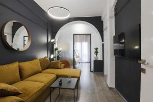 een woonkamer met een gele bank en een spiegel bij Ancient Agora Central Living in Thessaloniki
