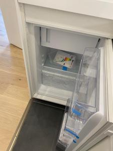 an empty refrigerator with its door open with a drawer at Lovely Apartment close to the Heart of Nürnberg in Nürnberg