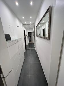 a hallway with white walls and a mirror on the wall at Lovely Apartment close to the Heart of Nürnberg in Nürnberg