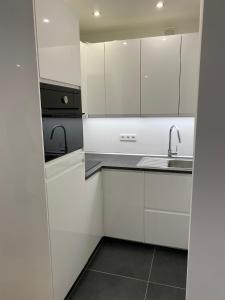 a kitchen with white cabinets and a sink at Lovely Apartment close to the Heart of Nürnberg in Nürnberg