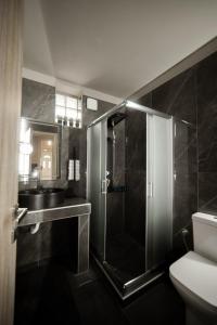 La salle de bains est pourvue d'une douche et d'un lavabo. dans l'établissement Rodon Premium, à Kalavrita