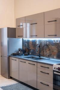 a kitchen with a sink and a stainless steel refrigerator at Rodon Premium in Kalavrita