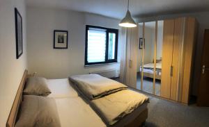 een slaapkamer met een bed, een raam en een spiegel bij Haus Nacke in Möhnesee