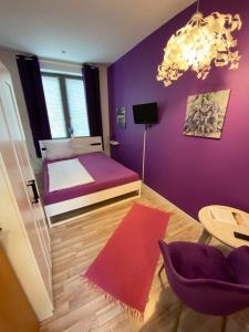 a bedroom with a bed and a purple wall at Gästehaus Lavendel in Flensburg