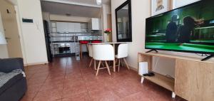 a living room with a large flat screen tv at Departamento cercano al faro y playa in La Serena +4 photos