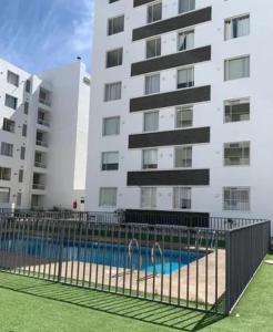 a building with a swimming pool in front of a building at Departamento cercano al faro y playa in La Serena
