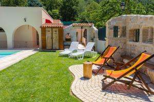 un patio con sillas y una piscina en Aria di Bosco en LʼAquila