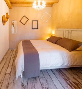 Un dormitorio con una cama grande y una lámpara de araña. en Aria di Bosco en LʼAquila