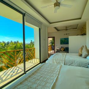 a bedroom with two beds and a balcony at Muúnek Hotel Boutique Art & Spa in Barra Vieja