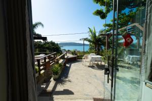 a view from the door of a restaurant with a table and chairs at Residencial Bombinhas Vista Mar in Bombinhas