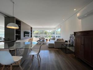 cocina y sala de estar con mesa y sillas en Apartamentos Altos da Bela Vista by Achei Gramado, en Gramado