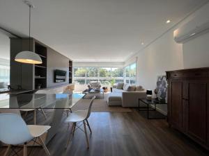 a kitchen and living room with a table and chairs at Apartamentos Altos da Bela Vista by Achei Gramado in Gramado