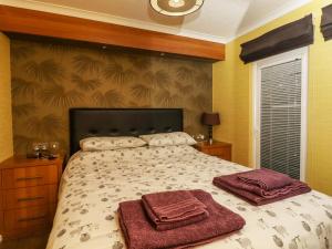 a bedroom with a bed with two towels on it at Swinsty Lodge in Harrogate