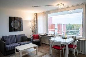 a living room with a couch and a table at Ferienwohnung Hooge 30 in Wyk auf Föhr