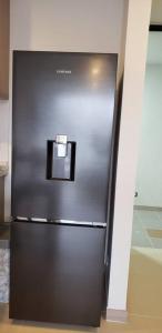 een zwarte koelkast in een kamer met een muur bij Robles10 El Cable Luxury Highrise in Manizales
